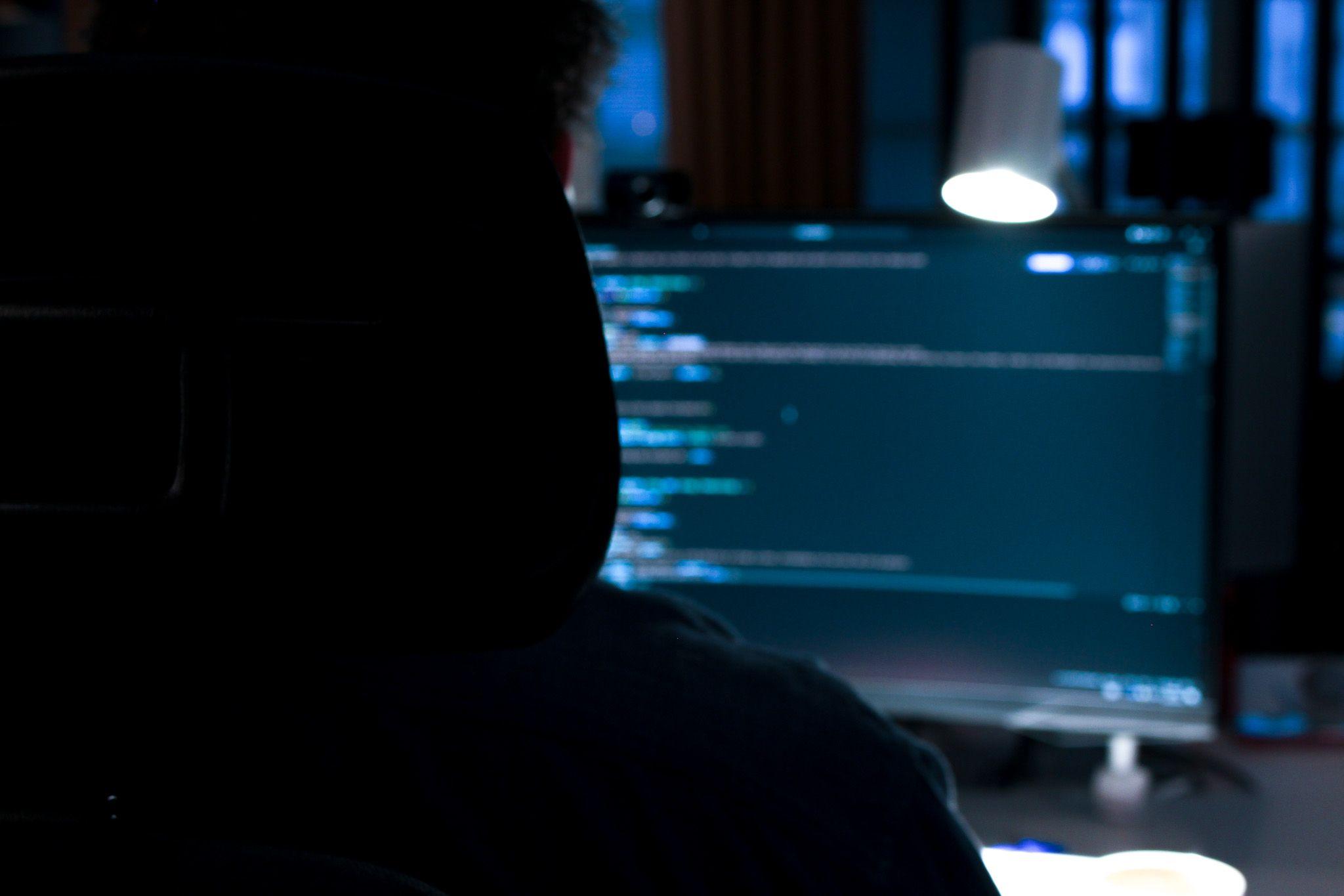 Vit skrivbordslampa lyser ner över datorskärm.